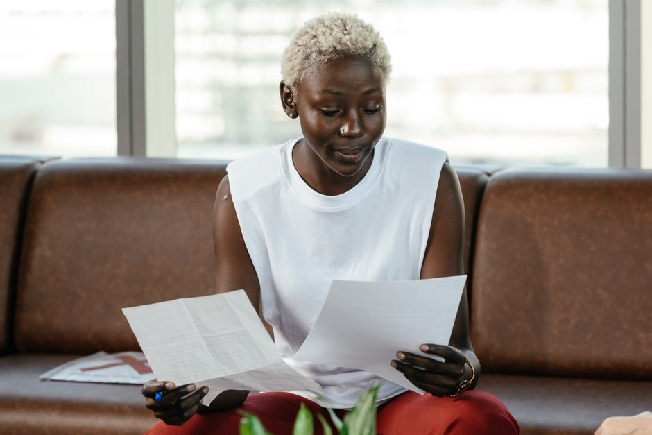 A focused entrepreneur comparing figures and documents while preparing a business plan